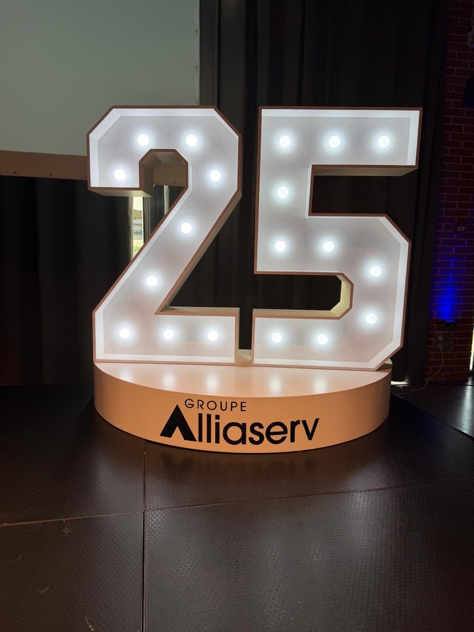 Chiffres lumineux géants 25 avec podium personnalisé au logo Groupe Alliaserv