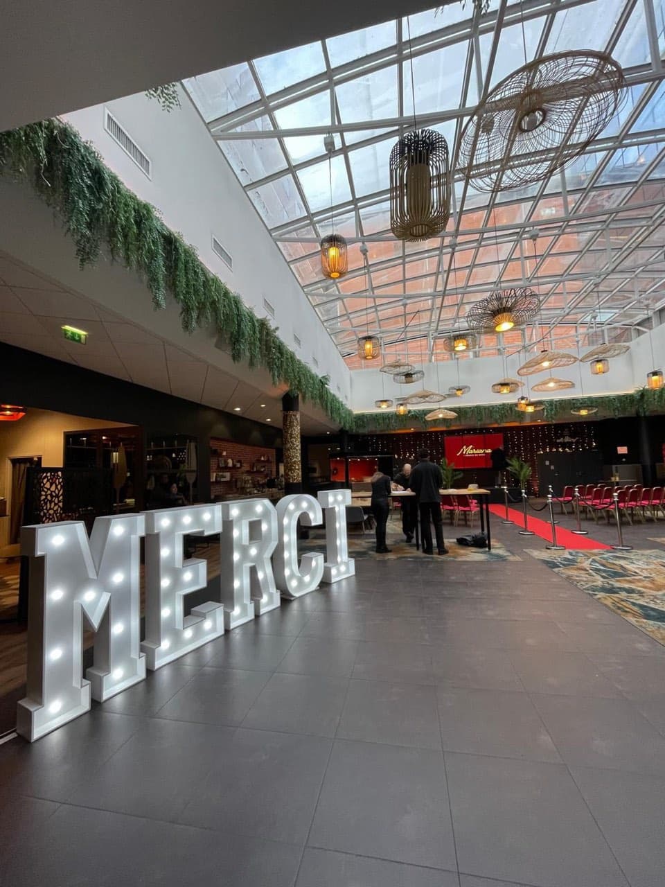 Lettres lumineuses géantes MERCI dans le hall d'un hôtel